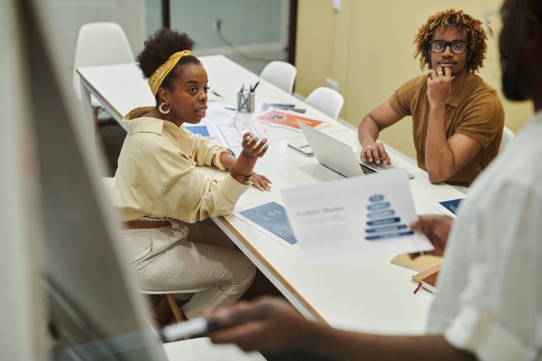 A diverse team collaborating and discussing business strategies over a meeting table