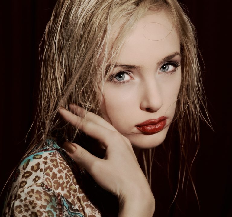 Close-up portrait of an elegant woman with striking gray eyes and wet hair
