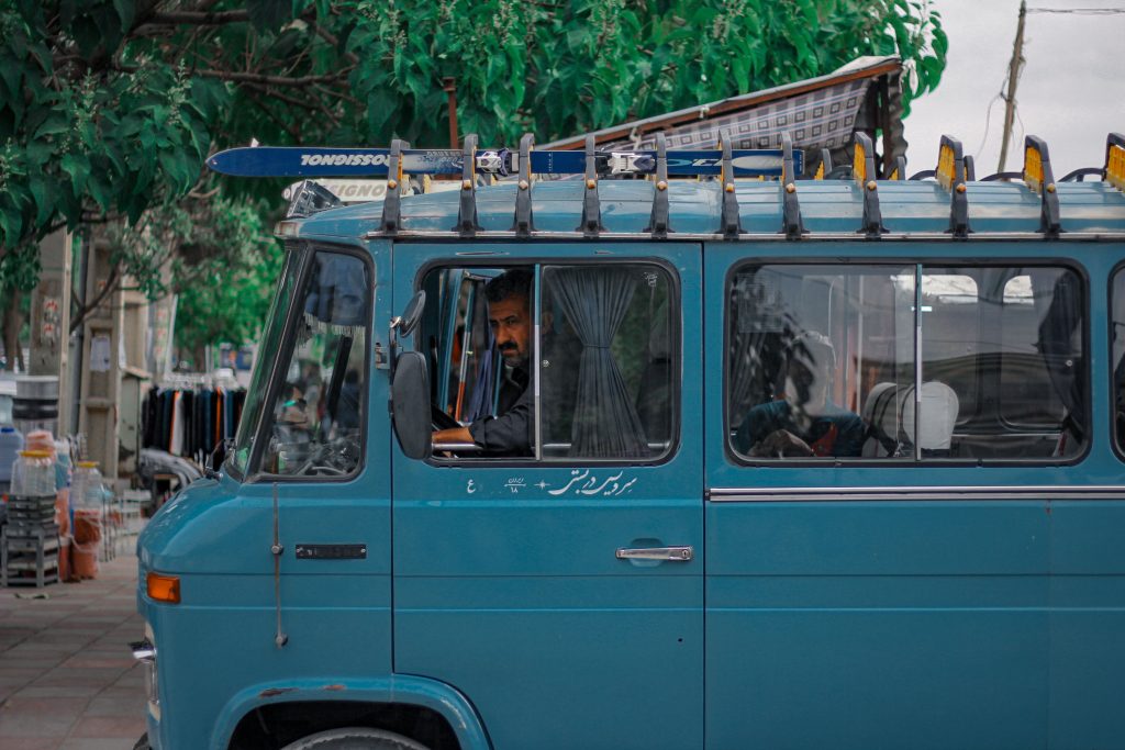 Blue van with a driver in an urban street setting, Kurdistan Province, Iran