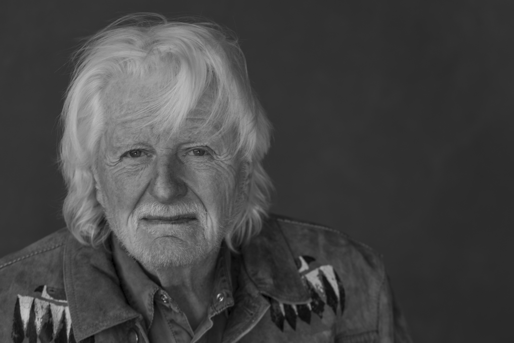 Marjoe Gortner in a black-and-white portrait wearing a denim shirt