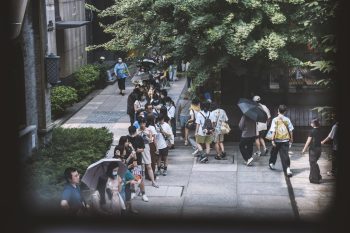 young people and official posing for smartphone photos