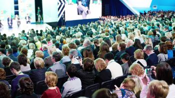 Audience seated at an annual general meeting facing the stage